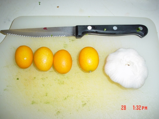 kumquats next to a garlic clove.